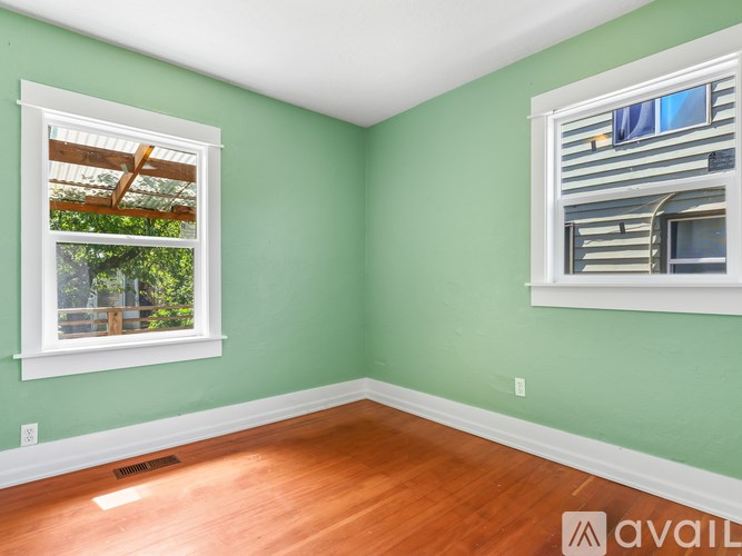 A room with a window and a wall-mounted air conditioning unit.