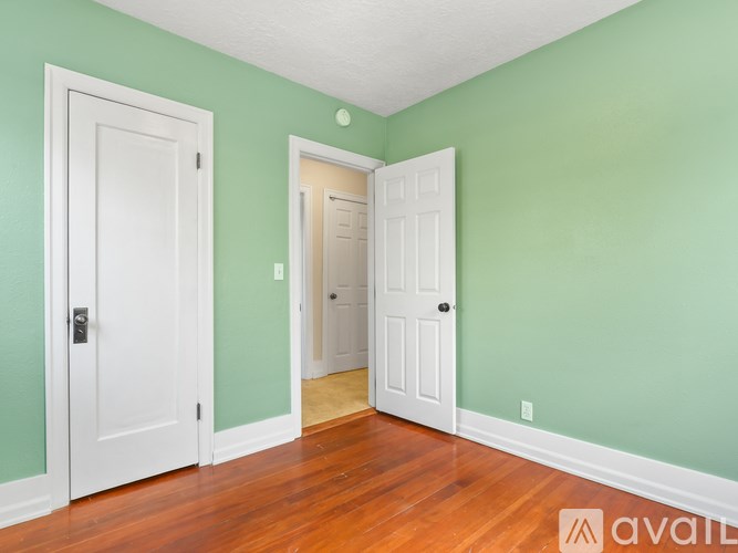 A room with two white doors and a wooden floor.