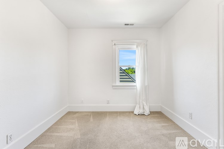 A room with a window and a carpeted floor.