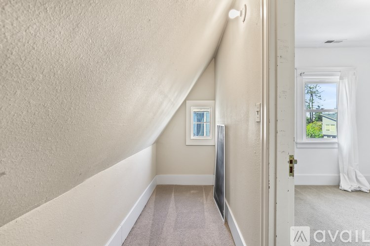 A hallway with a carpeted floor and a door on the right.