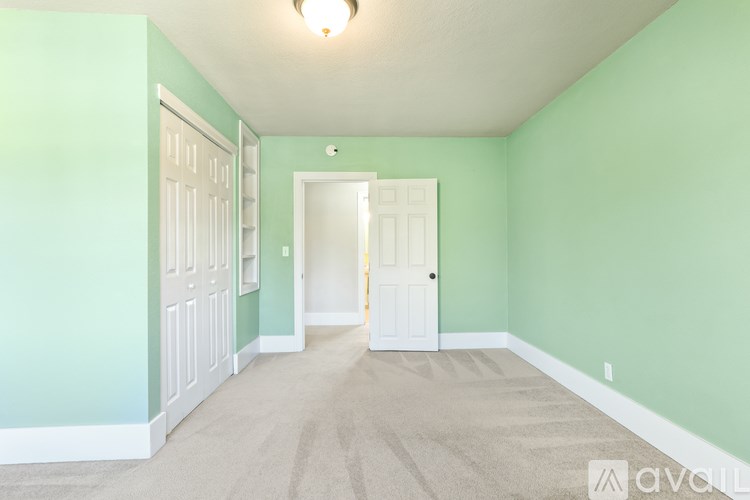 A hallway with a carpeted floor and two doors.