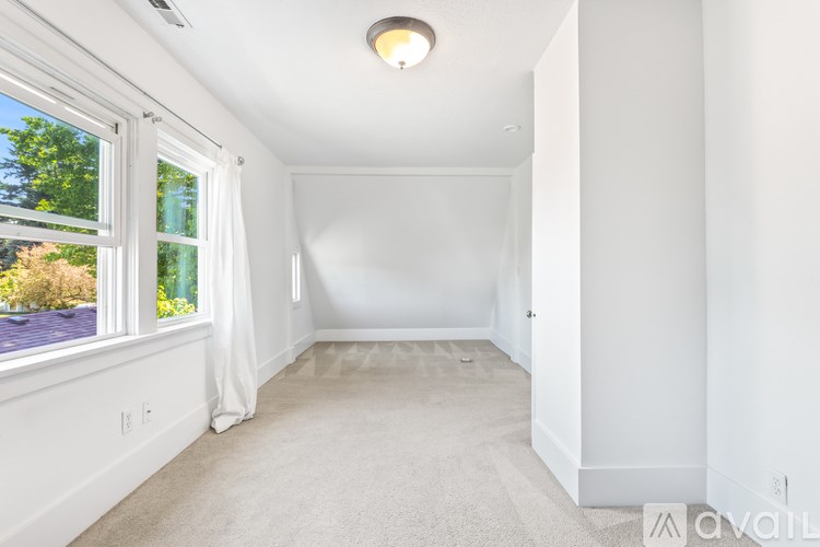 A white room with a window and carpeted floor.