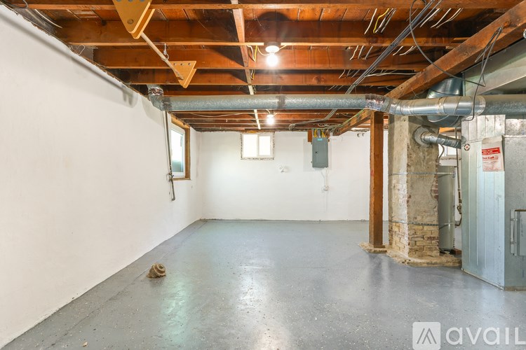 A large empty room with a concrete floor and exposed wooden beams on the ceiling.