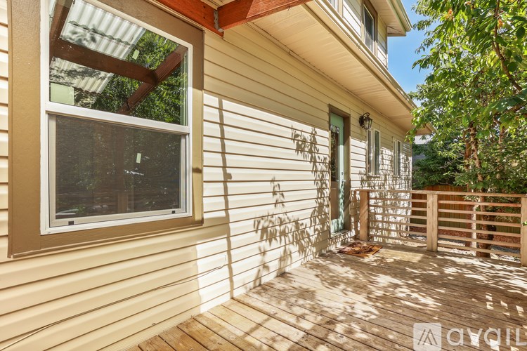 A wooden deck with a window and a wooden fence.