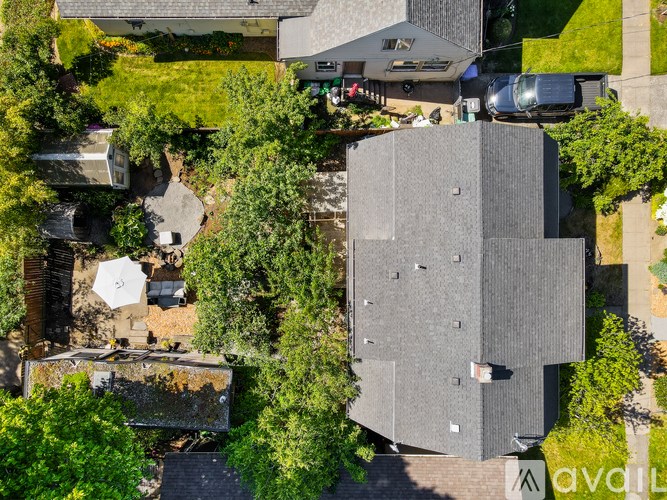 A modern building with a grey facade is surrounded by greenery.