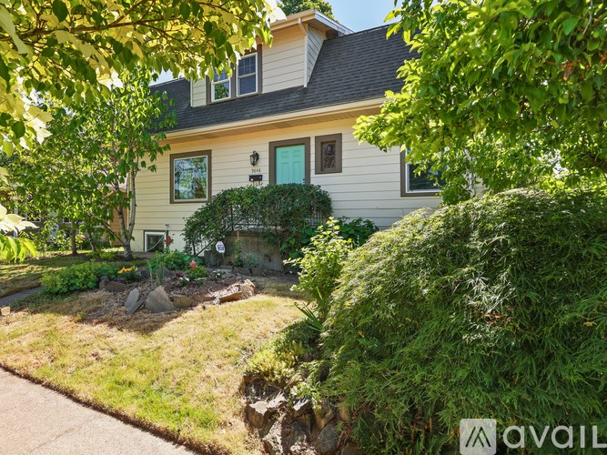 A house with a green lawn and trees in front.