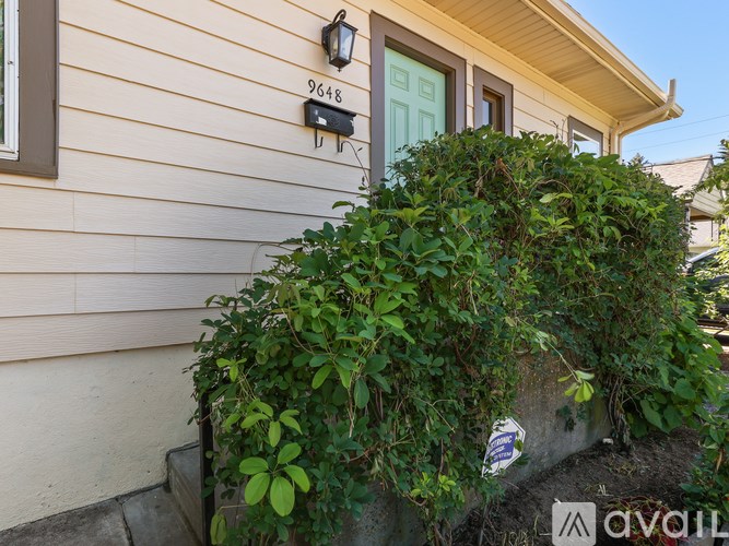 A house numbered 9648 with a green bush in front.