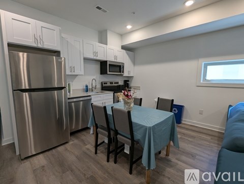 A kitchen with a table set for two and a refrigerator.