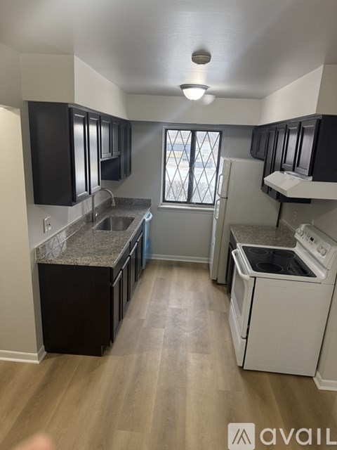 A kitchen with black cabinets and a white dishwasher.