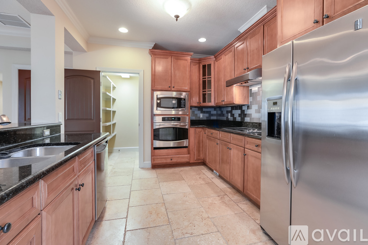 A kitchen with wooden cabinets and a stainless steel refrigerator.