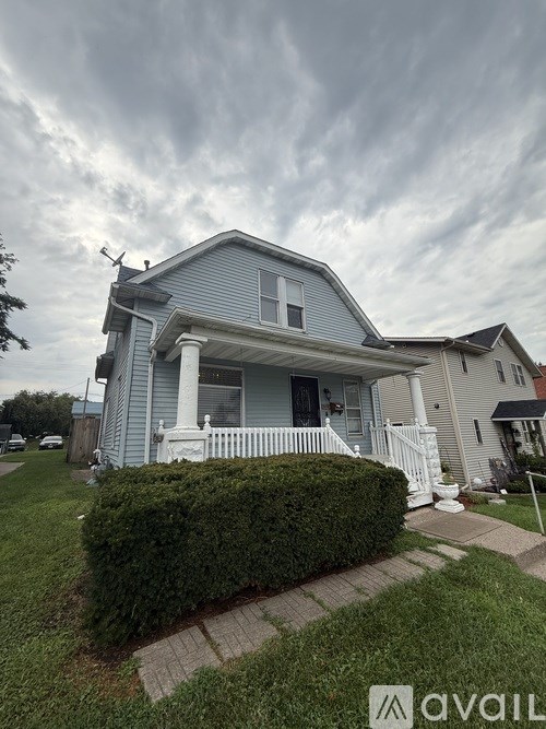 A house with a blue front and a white fence.