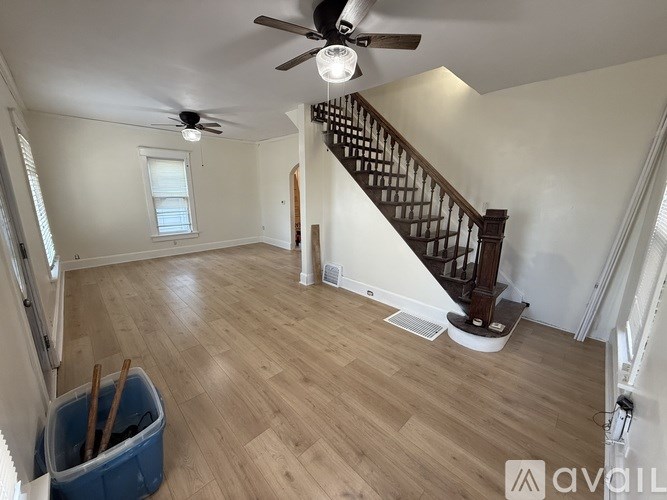 A room with a staircase and a ceiling fan.