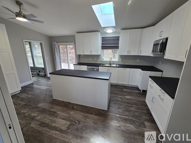 A kitchen with white cabinets and a granite countertop.