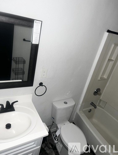A bathroom with a toilet, sink, and mirror.