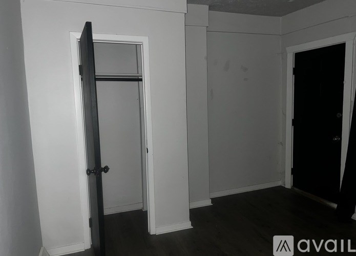 A room with a door and a wall with a hole in it.