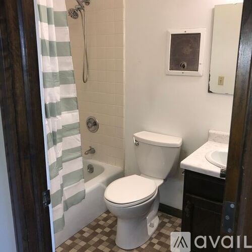A bathroom with a toilet, sink, and shower.