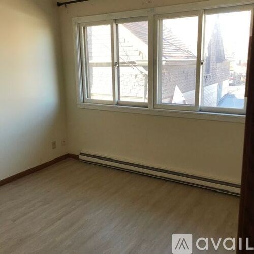 A room with a window showing a view of a cityscape.