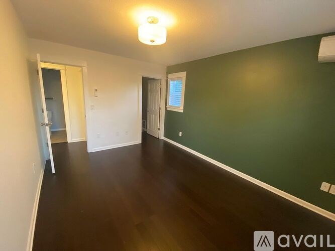 A room with green walls and wooden floors is available.