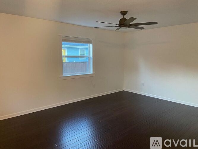 A room with a ceiling fan and a window.
