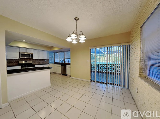 A kitchen with white cabinets and a black countertop is shown.