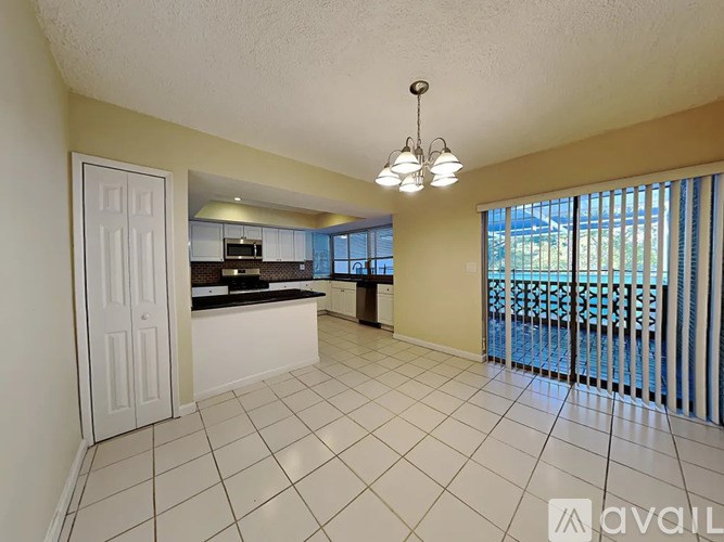 A spacious kitchen and living room with a balcony overlooking the backyard.