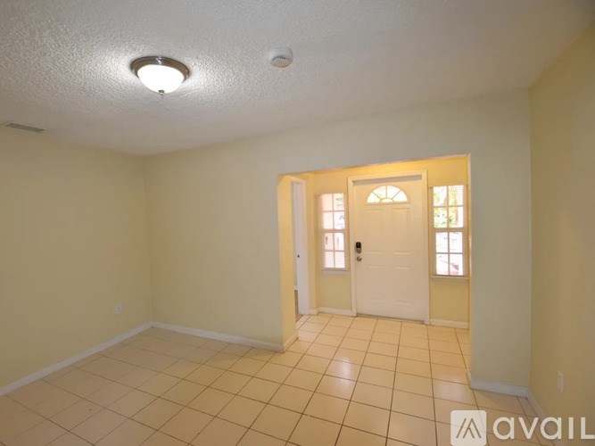 A room with a white door and tiled floor.