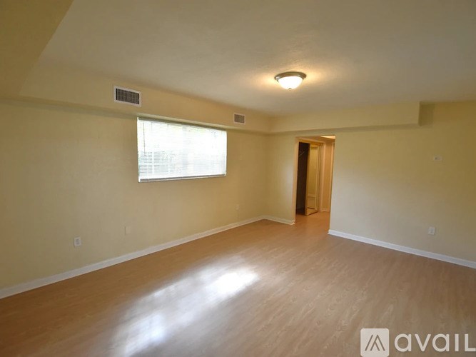 A room with a window and wooden flooring is available for rent.