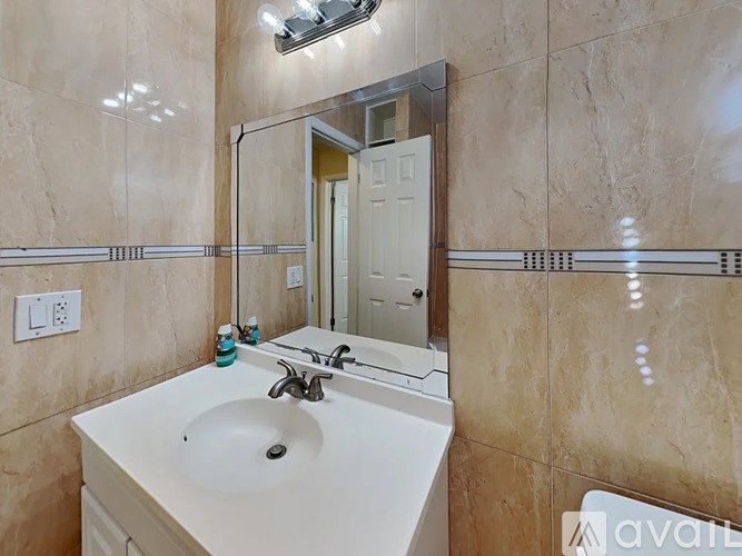 A bathroom with a sink, mirror, and a shower.
