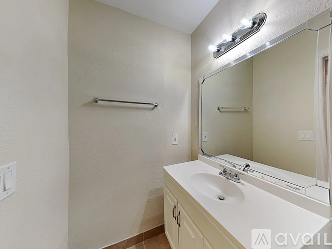 A bathroom with a sink, mirror, and light fixture.