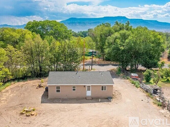 A house is surrounded by trees in a field.