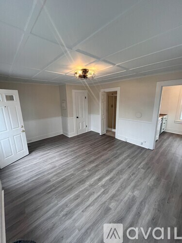 A room with wooden flooring and white walls.