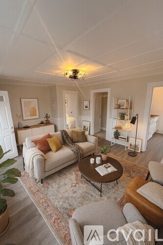 A living room with a couch, a coffee table, and a rug.