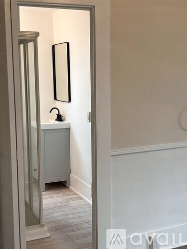 A bathroom with a white cabinet and a mirror.