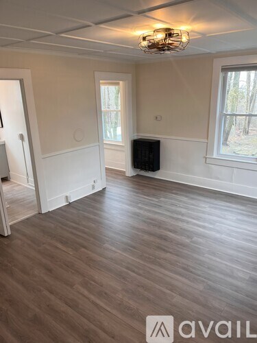 A room with wooden flooring and a chandelier.