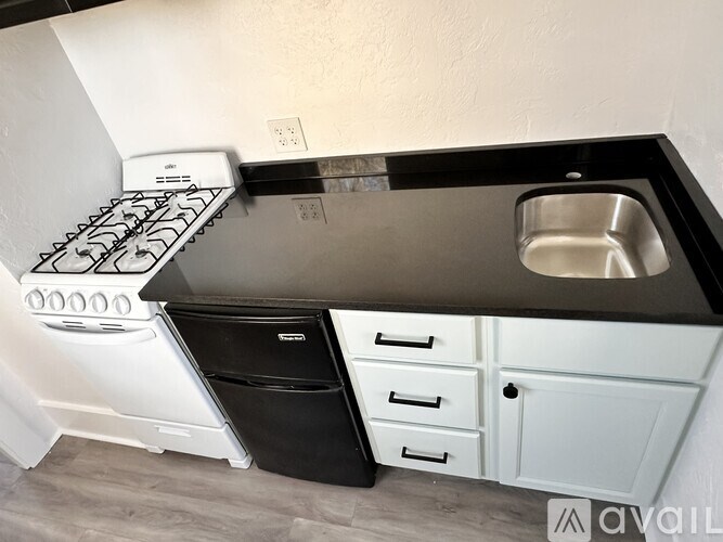 A modern kitchen with a black countertop and white appliances.