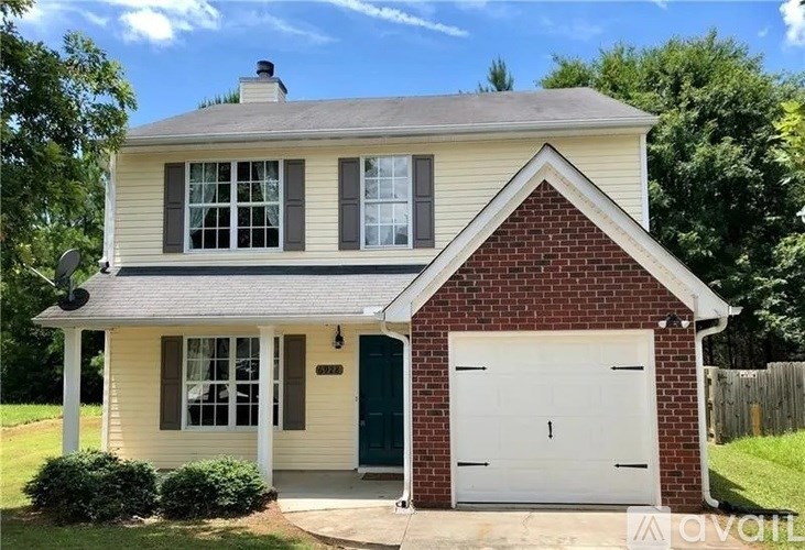 A two-story house with a garage door and a green door.