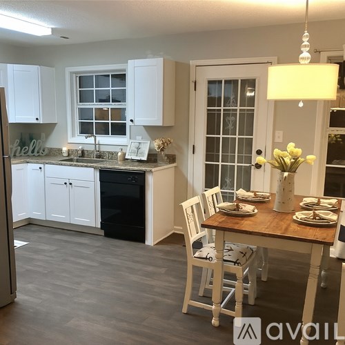 A kitchen with a table set for two and a fridge on the left.