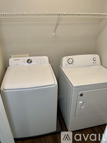 Two white front loading washing machines in a small room.