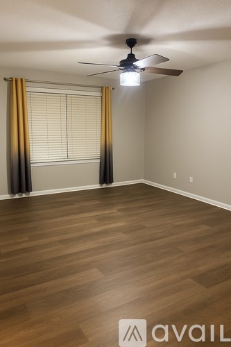A room with wooden flooring and a ceiling fan.
