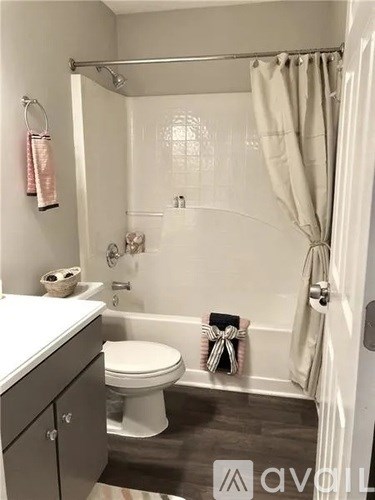 A white toilet sits next to a bathtub in a bathroom.
