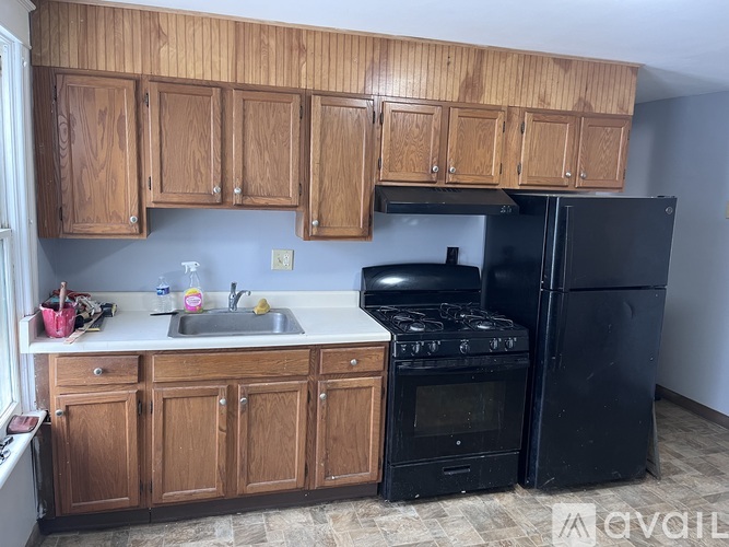 A kitchen with wooden cabinets and black appliances.