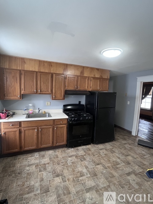 A kitchen with wooden cabinets and black appliances.