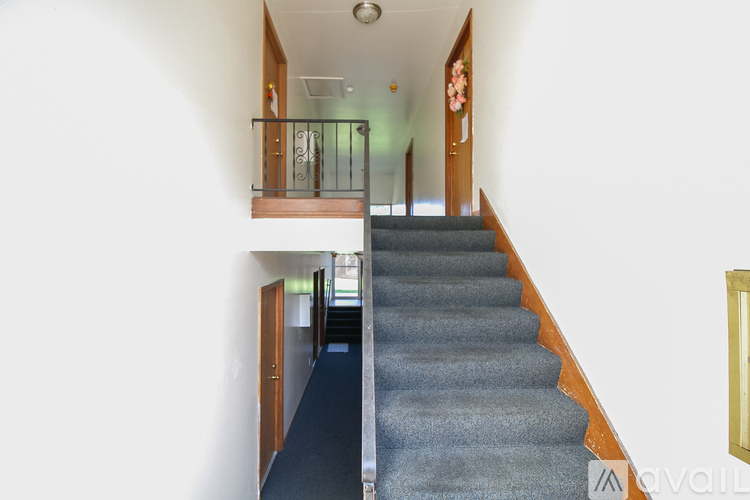A staircase with a carpeted runner and wooden handrail.