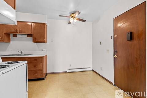 A kitchen with a white dishwasher and a white stove with wooden cabinets.