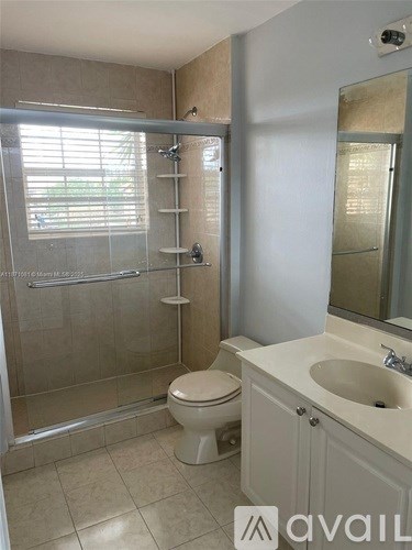 A bathroom with a toilet, sink, and shower.