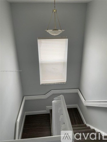 A staircase with a light hanging above it.