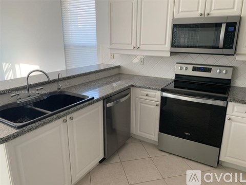 A kitchen with white cabinets and a black stove top oven.