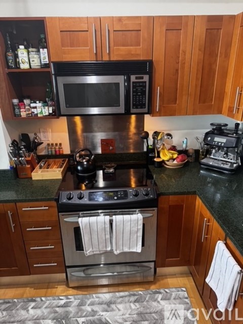 A kitchen with a black stove top oven and a black microwave above it.