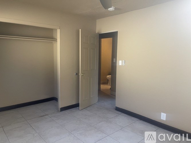 A room with a beige wall and a brown door.
