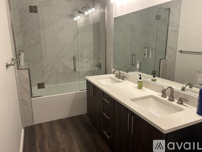 A bathroom with a marble tile shower and a white countertop.